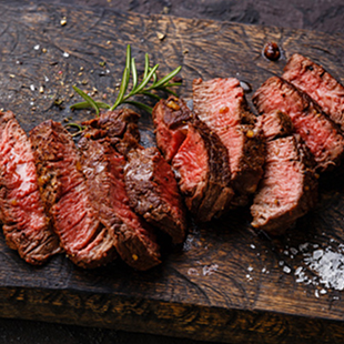 Eine Fleischspezialität aus Uruguay aufgeschnitten serviert auf Holzbrett