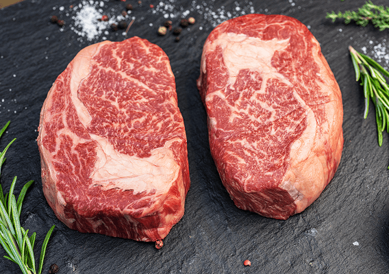 Zwei rohe Steaks auf einer Schieferplatte