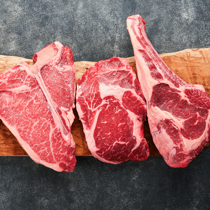 Eine Auswahl an drei Fleischedelstücken auf einem Holzbrett