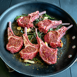 Eine Pfanne mit marinierten Fleischstücken vom Lamm