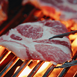 Ein Fleischstück wird auf einem Grill gegrillt