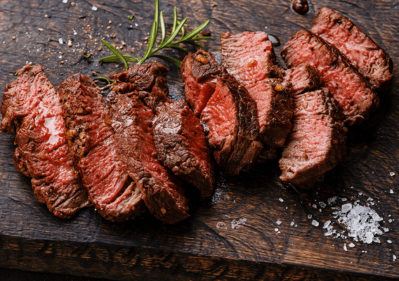 Eine Fleischspezialität aus Uruguay aufgeschnitten serviert auf Holzbrett